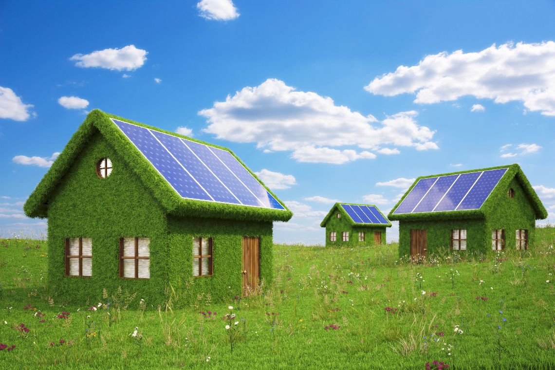 houses from the grass with solar panels on the roof.